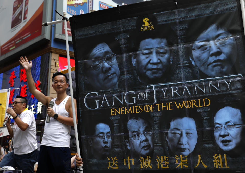 FILE - In this June 9, 2019, file photo, protesters display a banner with images of Chinese President Xi Jinping during a march along a downtown street against the proposed amendments to an extradition law in Hong Kong. Hong Kong's protests come at a sensitive time for President Xi Jinping, who after removing presidential term limits last year, effectively made himself leader for life. That has intensified criticism over his concentration of power, even as his propaganda machine relentlessly promotes his image and achievements ahead of the 70th anniversary of the founding of the People's Republic on Oct. 1. (AP Photo/Vincent Yu, File)