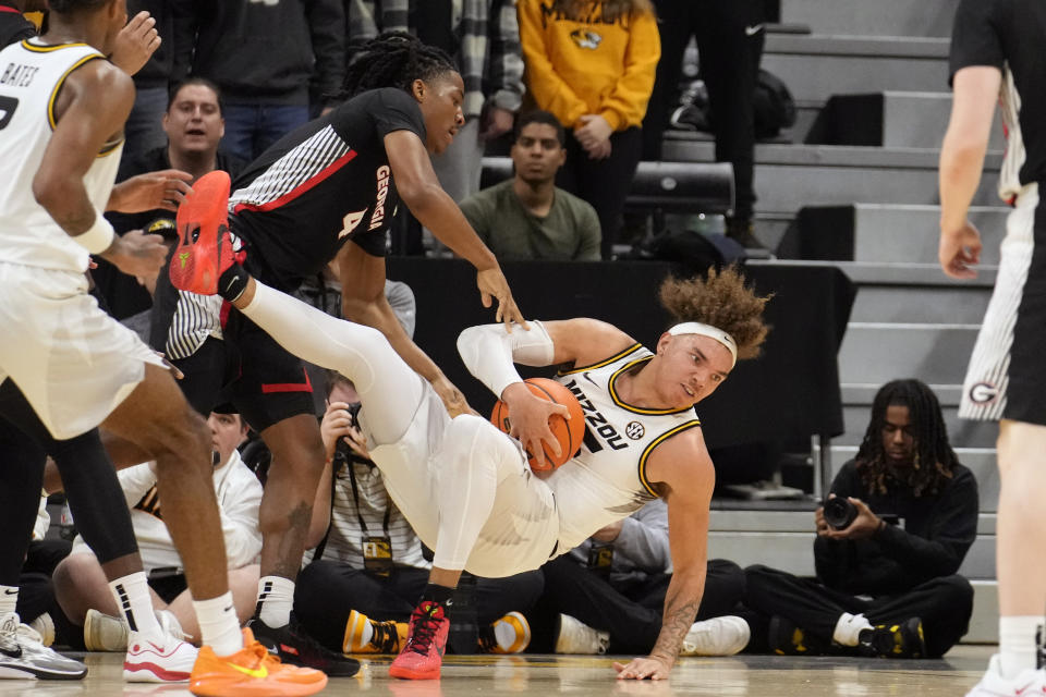 Missouri's Noah Carter, right, falls after battling Georgia's Silas Demary Jr. (4) for the ball during the first half of an NCAA college basketball game Saturday, Jan. 6, 2024, in Columbia, Mo. (AP Photo/Jeff Roberson)