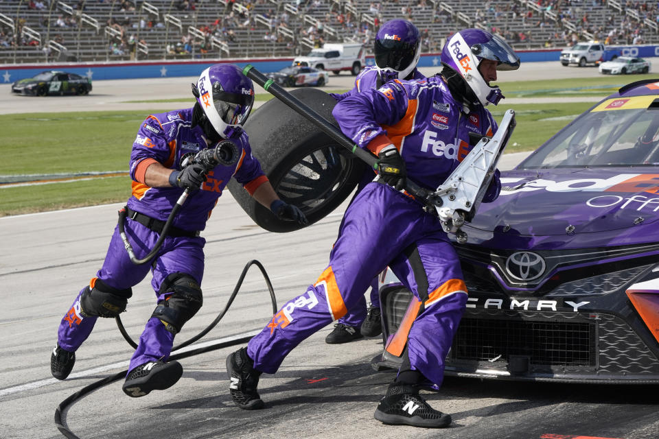 Denny Hamlin's pit crew change tires during the NASCAR Cup Series auto race at Texas Motor Speedway in Fort Worth, Texas, Sunday, Sept. 25, 2022. (AP Photo/Larry Papke)