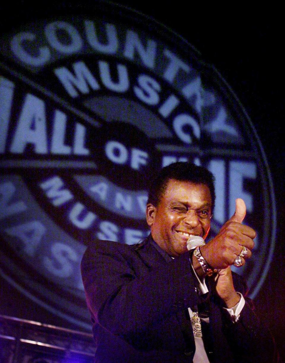 An exuberant Charley Pride, while singing a few songs, flashes a thumbs up to a friend in the audience after receiving a medallion along with the family of Faron Young commemorating their 2000 inductions into the Country Music Hall of Fame on March 13, 2001.