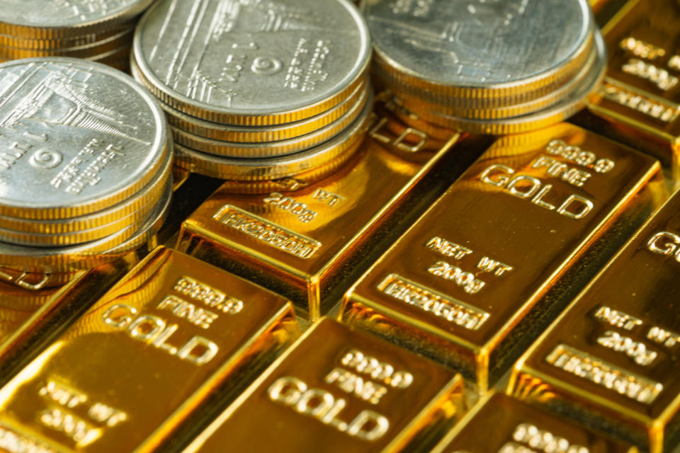 selective focus on shiny gold bars with stack of coins as business or financial investment and wealth concept.