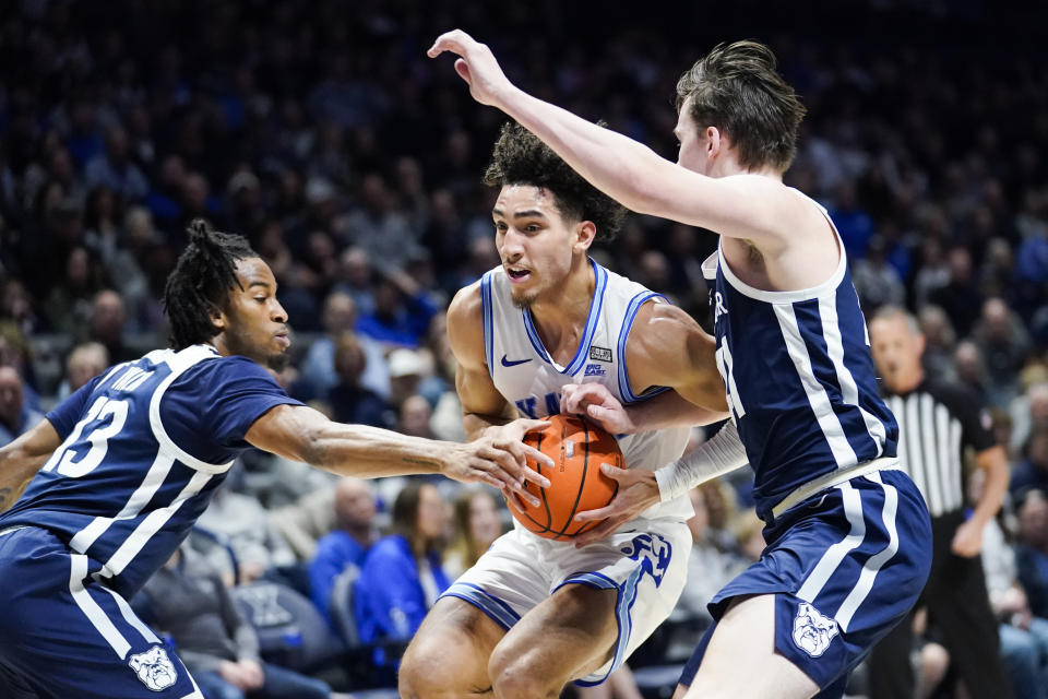 Xavier guard Colby Jones (3) drives to the basket as Butler guards Jayden Taylor, left, and Simas Lukosius, right, defend during the first half of an NCAA college basketball game, Saturday, March 4, 2023, in Cincinnati. (AP Photo/Joshua A. Bickel)