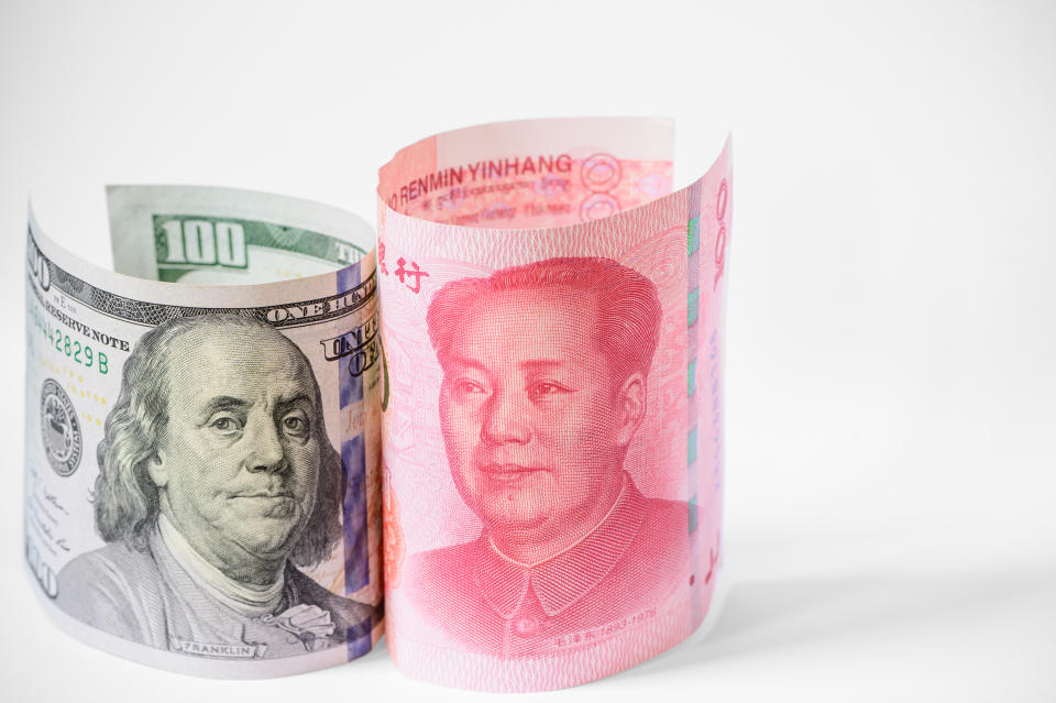US dollar and China Yuan banknote stand up on white background.