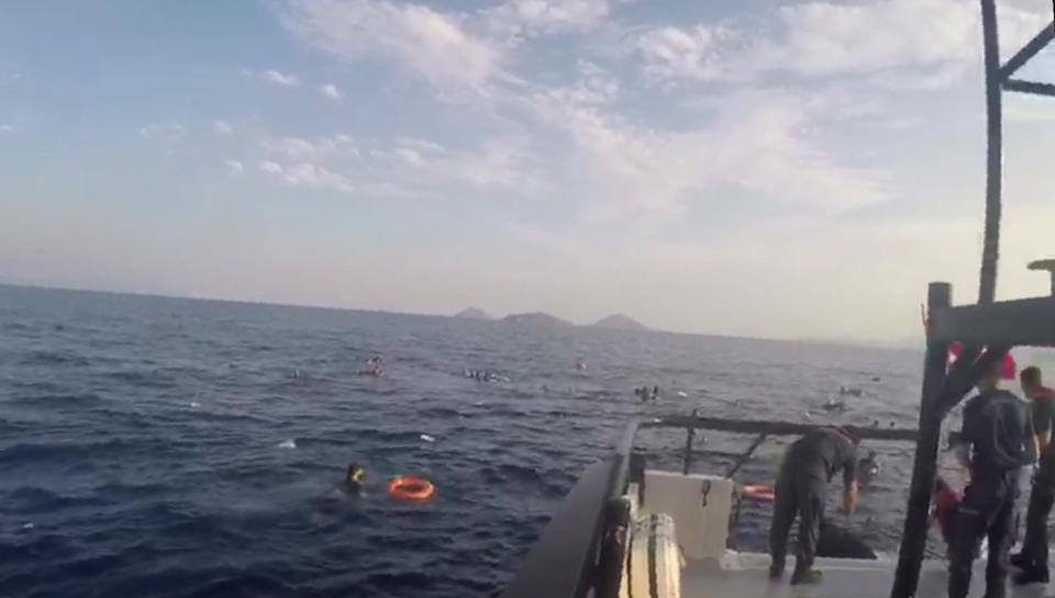 In this image taken from video made available by the Turkish Coastguard on Monday June 17, 2019, a coast guard boat approaches migrants in the Aegean Sea. A boat carrying migrants to Greece sank off the Turkish coast on Monday leaving at least eight migrants dead Turkey's coast guard said. The coast guard said 31 other migrants were rescued after the boat sank in the Aegean Sea, off the coast of Bodrum. (Turkish Coastguard via AP)