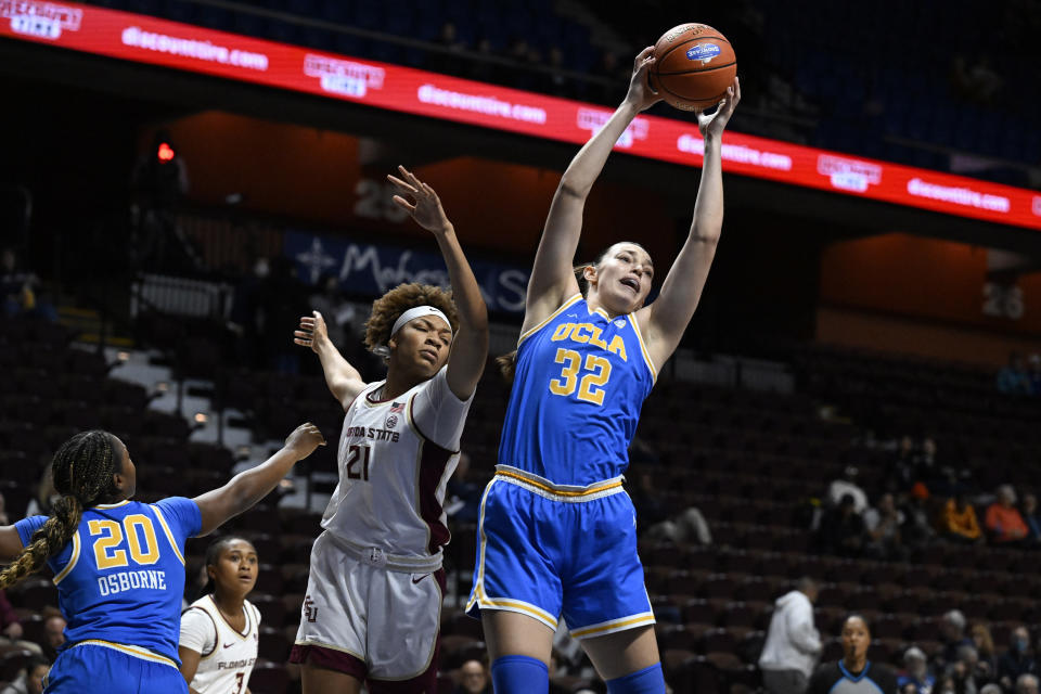 UCLA forward Angela Dugalic (32) grabs a rebound over Florida State forward Makayla Timpson (21) in the first half of an NCAA college basketball game, Sunday, Dec. 10, 2023, in Uncasville, Conn. (AP Photo/Jessica Hill)