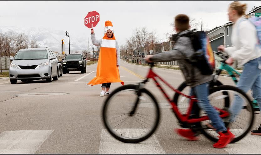 Whitney Durfee works as a crossing guard outside Trailside Elementary School in Vineyard on Friday. Durfee started dressing as a traffic cone to raise awareness for the importance of avoiding distracted driving and speeding in school zones. 