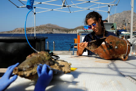 Student of the Department of Conservation of Antiquities and Works of Art Eirini Mitsi, 23, works on an amphora retrieved from a shipwreck site on the island of Fournoi, Greece, September 20, 2018. Picture taken September 20, 2018. REUTERS/Alkis Konstantinidis