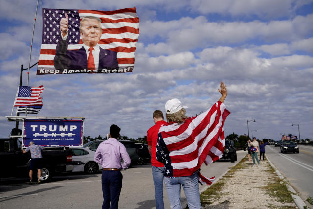 Evelyn Knapp, a supporter of former President Donald, waves to passersby outside of Trump's Mar-a-Lago estate, Monday, March 20, 2023, in Palm Beach, Fla. (AP Photo/Lynne Sladky)