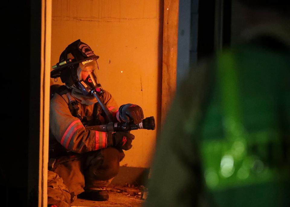 A firefighter from the Vesper Fire Department keeps an eye on a fire after a training exercise on Monday, August 1, 2022, at 4470 Neitzel Rd near Wisconsin Rapids, Wis. Firefighters from eight departments around central Wisconsin came together to train for various house fire scenarios before demolishing the house in a controlled burn.Tork Mason/USA TODAY NETWORK-Wisconsin 