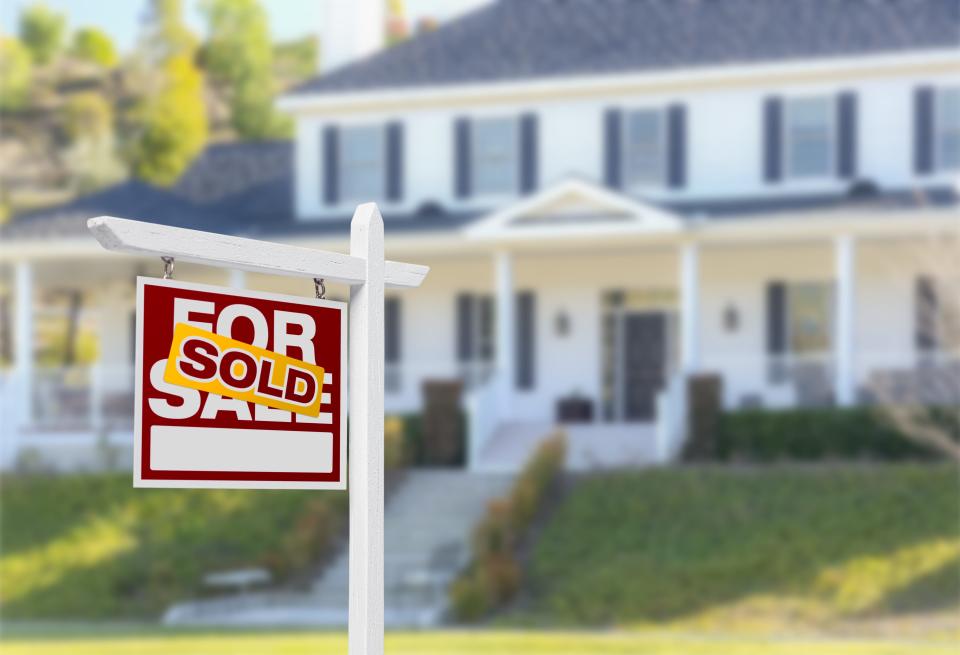 Sold Home For Sale Real Estate Sign in Front of Beautiful New House.