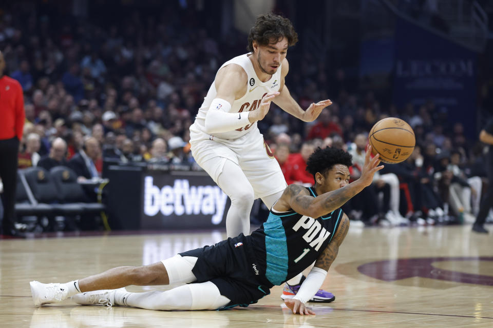 Portland Trail Blazers guard Anfernee Simons (1) passes as Cleveland Cavaliers forward Cedi Osman (16) closes in during the first half of an NBA basketball game, Wednesday, Nov. 23, 2022, in Cleveland. (AP Photo/Ron Schwane)