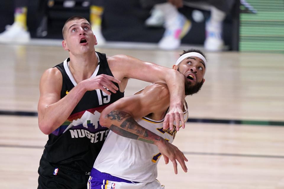 Denver Nuggets' Nikola Jokic (15) and Los Angeles Lakers' JaVale McGee, right, compete for a rebound during the first half of Game 3 of the NBA basketball Western Conference final Tuesday, Sept. 22, 2020, in Lake Buena Vista, Fla. (AP Photo/Mark J. Terrill)