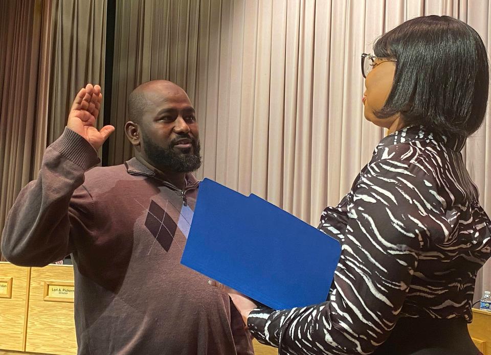 Newly appointed Erie School Director Zakaria Sharif, at left, takes the oath of office administered by Erie School Board Secretary Angela Jones at the board meeting on Wednesday night at East Middle School.