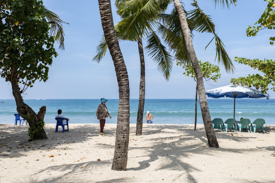 Tourists walk on a beach in Kuta, Bali, Indonesia, 19 October 2021.