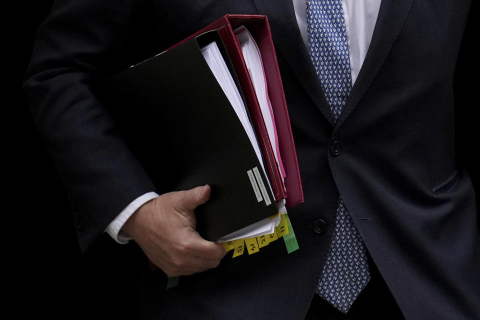 British Prime Minister Boris Johnson carries his folders as he leaves 10 Downing Street to attend the weekly Prime Minister's Questions at the Houses of Parliament, in London, Wednesday, May 25, 2022. A report into lockdown-breaching U.K. government parties says blame for a "culture" of rule-breaking in Prime Minister Boris Johnson's office must rest with those at the top. Senior civil servant Sue Gray's long-awaited report was published Wednesday. (AP Photo/Matt Dunham)