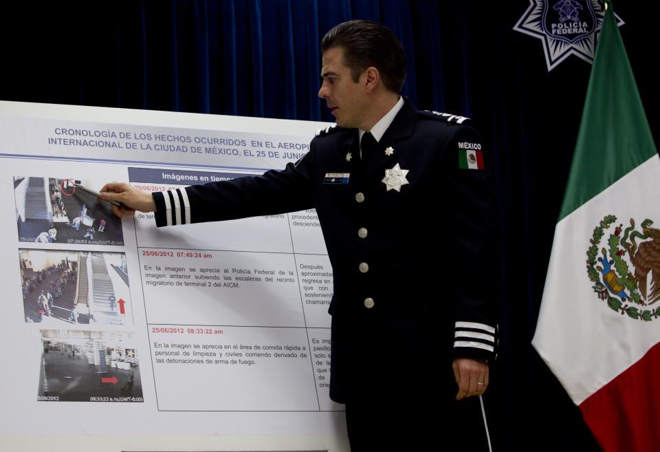 Luis Cardenas, chief of regional security division of the federal police of Mexico, points to surveillance camera footage at the international airport related to a shooting, during a press conference in Mexico City, Thursday, June 28, 2012. Two federal police officers suspected of working for drug traffickers opened fire on fellow officers in a crowded food court Monday, June 25, 2012, killing three policemen. The officers remain at large. (AP Photo/Esteban Felix)