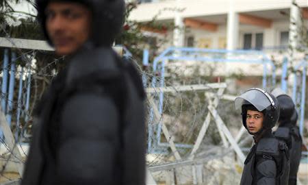 Riot police stand guard outside the police academy, where the trial of ousted Egyptian President Mohamed Mursi and members of the Muslim Brotherhood is due to take place, on the outskirts of Cairo February 16, 2014. REUTERS/Amr Abdallah Dalsh