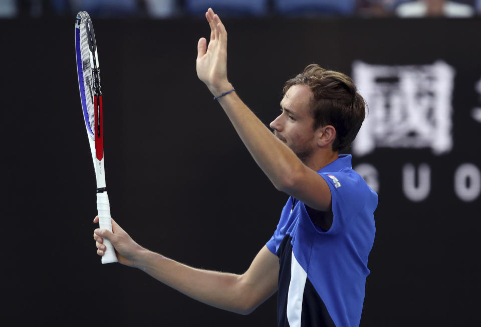 In this Jan. 21, 2020, photo, Russia's Daniil Medvedev signals to his opponent Frances Tiafoe of the U.S. after his ball hit the net during their first round singles match at the Australian Open tennis championship in Melbourne, Australia. It might just be the most insincere gesture in sports: A tennis player signals an apology after a ball clips the net tape and trickles over, producing a winner, an obviously accidental winner, to end a point. (AP Photo/Lee Jin-man)