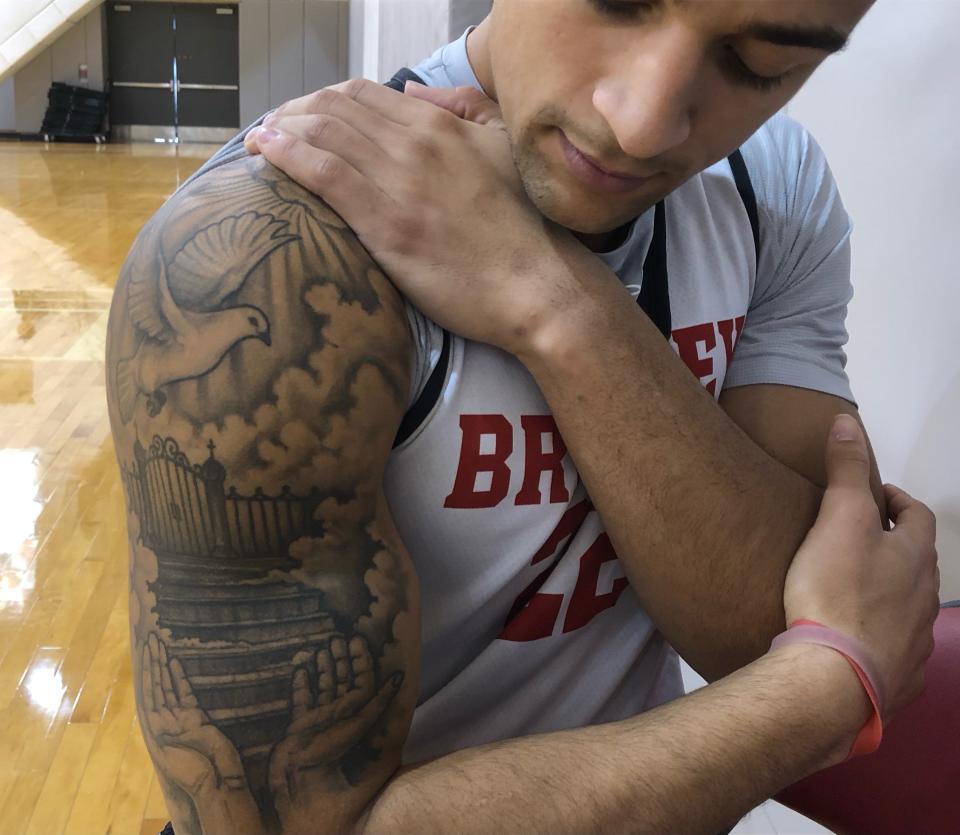 Bradley University senior forward Ja'Shon Henry shows the tattoo in memory of his late father, Air Force veteran Claude Henry, depicting his father's hands opening to a stairway to Heaven.