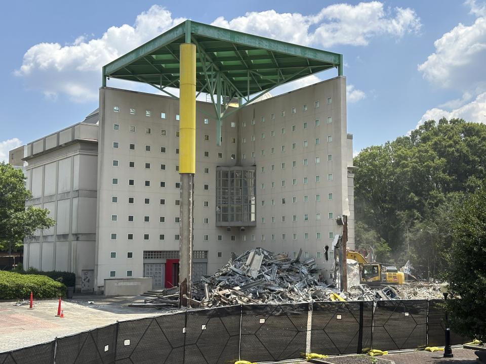 Workers knock downa former Coca-Cola Co. museum in downtown Atlanta on Friday, May 14, 2024. The World of Coca-Cola museum moved to a new site in downtown Atlanta in 2006 and Georgia state government is demolishing the vacant structure to turn it into a parking lot. (AP Photo/Jeff Amy)