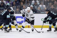 Los Angeles Kings right wing Arthur Kaliyev (34) skates with the puck between Seattle Kraken right wing Daniel Sprong (91) and left wing Brandon Tanev (13) during the first period of an NHL hockey game Saturday, April 1, 2023, in Seattle. (AP Photo/John Froschauer)