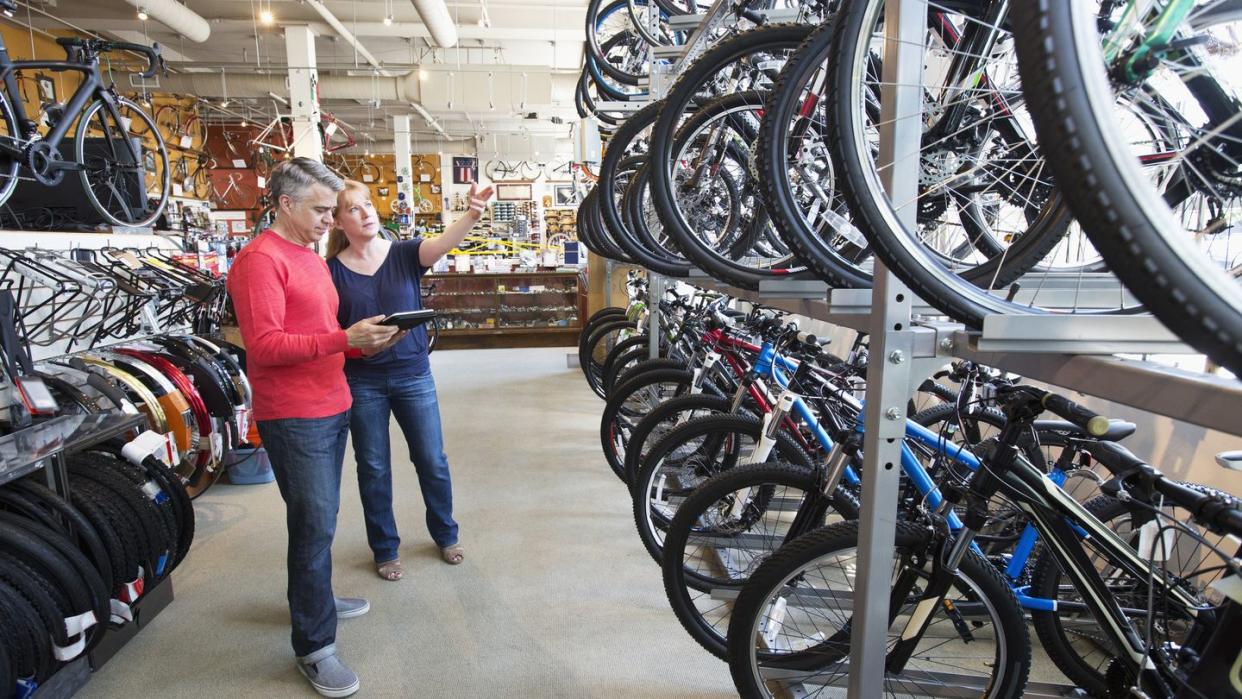 salesman showing bicycles to customer in bicycle shop