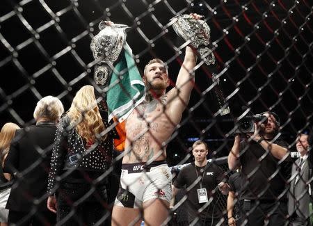 Nov 12, 2016; New York, NY, USA; Conor McGregor (blue gloves) celebrates with his two championship belts after defeating Eddie Alvarez (red gloves) in their lightweight title bout during UFC 205 at Madison Square Garden. Mandatory Credit: Adam Hunger-USA TODAY Sports