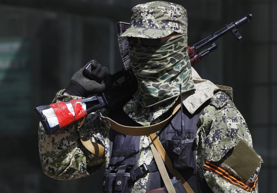 A pro Russian masked armed man guards at the city hall in Kostyantynivka, 35 kilometers (22 miles) south of Slovyansk, eastern Ukraine, Monday, April 28, 2014, after masked militants with automatic weapons seized the hall building. Ukraine's acting government and the West have accused Russia of orchestrating the unrest, which they fear Moscow could use as a pretext for an invasion. (AP Photo/Sergei Grits)