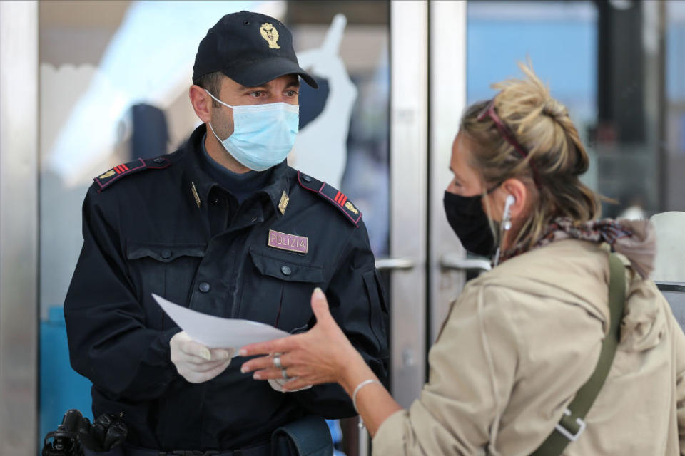 A woman delivers a self-declaration to a policeman in the Naples railway station.