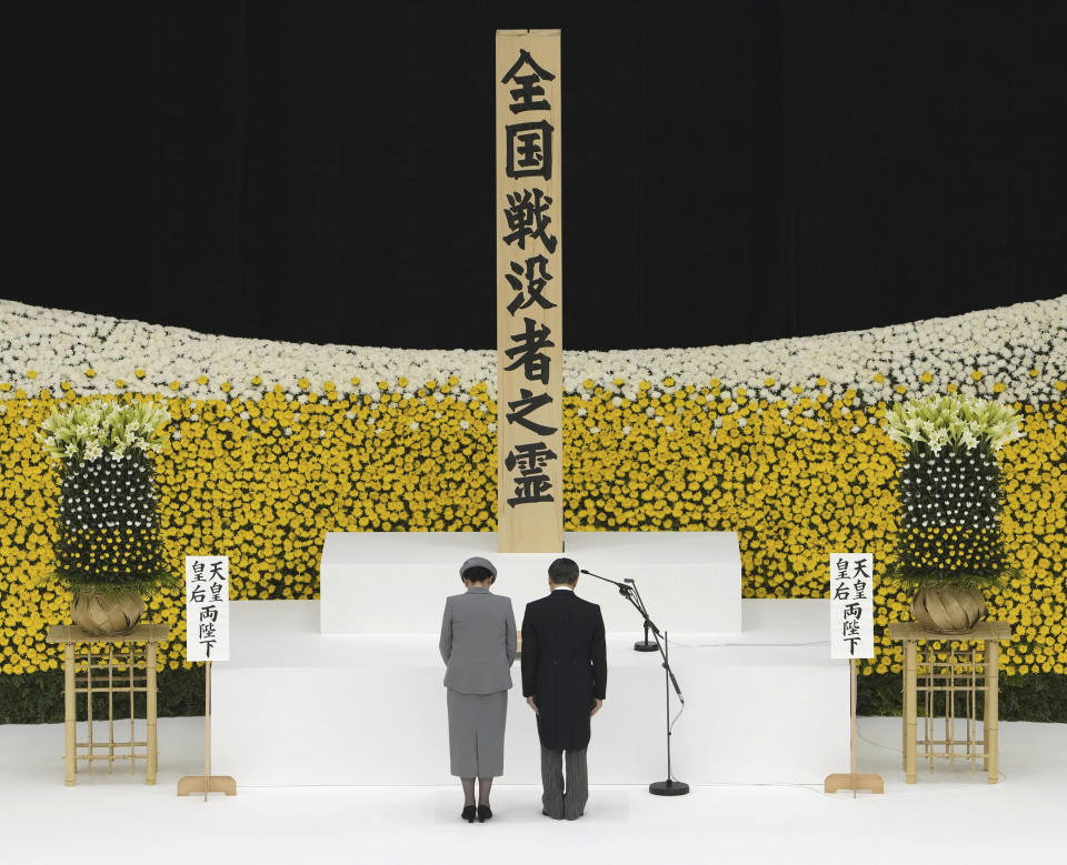 Japan's Emperor Naruhito, right, and Empress Masako observe a moment of silence during a memorial service for the war dead as Japan marks the 78th anniversary of Japan's World War II defeat, at the Nippon Budokan hall in Tokyo, Tuesday, Aug. 15, 2023.(Kyodo News via AP)