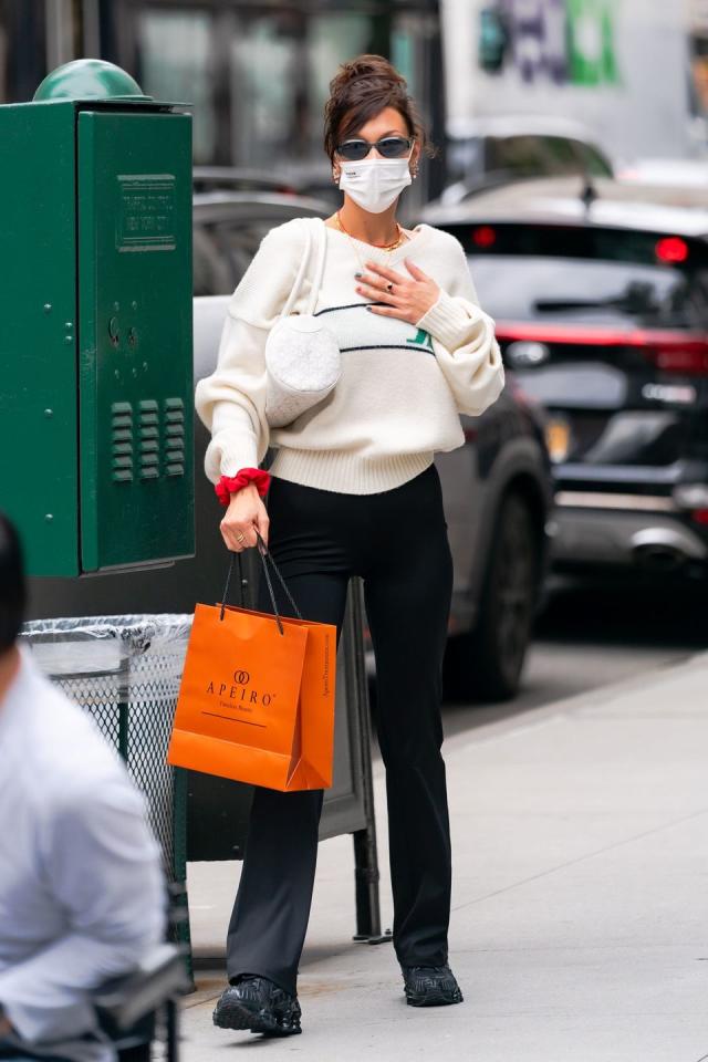 Bella Hadid wears a gingham blazer and a sweater as she rides a scooter  home from dinner