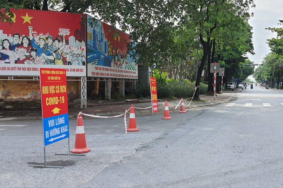 A street is cordoned off to control the traffic in Hanoi, Vietnam, Saturday, July 24, 2021. Vietnam announced a 15-day lockdown in the capital Hanoi starting Saturday as a coronavirus surge spread from the southern Mekong Delta region. (AP Photo/Hieu Dinh)