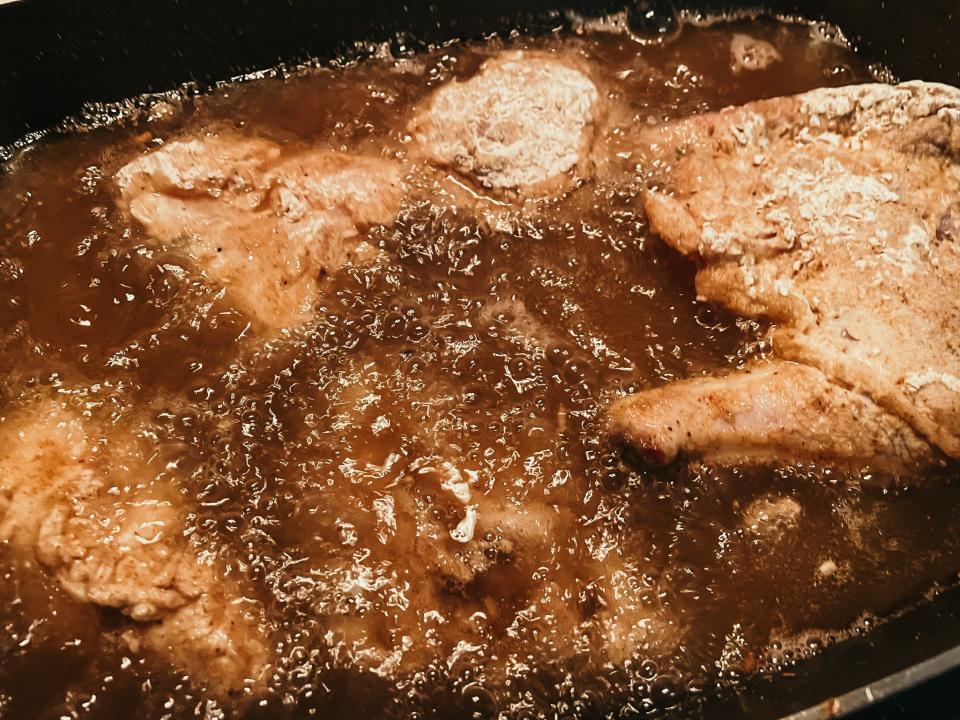chicken frying in a pan of hot oil