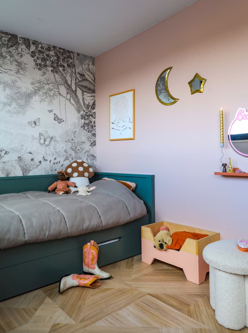 Daybed placed against pink wall in child's bedroom.