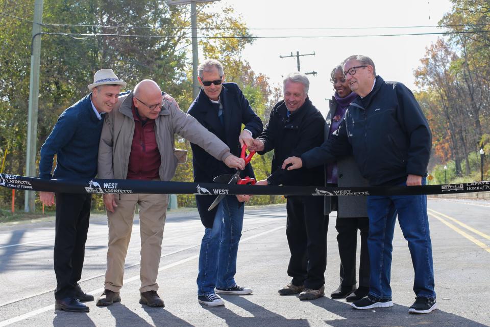 West Lafayette City Councilmen David Sander and Peter Bunder, West Lafayette Mayor John Dennis, West Lafayette Utility Director, Dave Henderson, and West Lafayette City Clerk Sana G. Booker cut the ribbon for the reopening of North River Road after an 18th month closure due to construction, on Wednesday, Nov. 1, 2023, in West Lafayette, Ind.