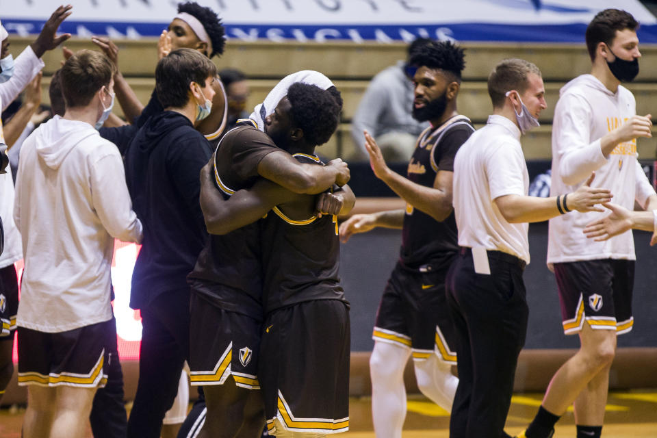 Valparaiso's Zion Morgan, center left, and Daniel Sackey hug after defeating Drake in an NCAA college basketball game on Sunday, Feb. 7, 2021, in Valparaiso, Ind. (AP Photo/Robert Franklin)