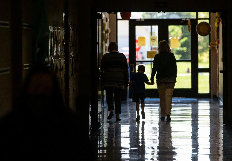 A student walks down the hallway with a member of the staff at Rochester Elementary School in Rochester, Ill., Wednesday, September 15, 2021. [Justin L. Fowler/The State Journal-Register] 