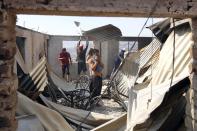 Residents work to remove the remains of a house after a forest fire burned several neighbourhoods in the hills in Valparaiso city, northwest of Santiago, April 13, 2014. At least 11 people were killed and 500 houses destroyed over the weekend by a fire that ripped through parts of Chilean port city Valparaiso, as authorities evacuated thousands and used aircraft to battle the blaze. REUTERS/Eliseo Fernandez (CHILE - Tags: SOCIETY ENVIRONMENT DISASTER)