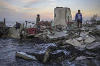 Yahir Mayoral and Emily Camacho walk amid the rubble of their grandmother's home, destroyed by flooding driven by a sea-level rise in their coastal community of El Bosque, in the state of Tabasco, Mexico, Thursday, Nov. 30, 2023. (AP Photo/Felix Marquez)