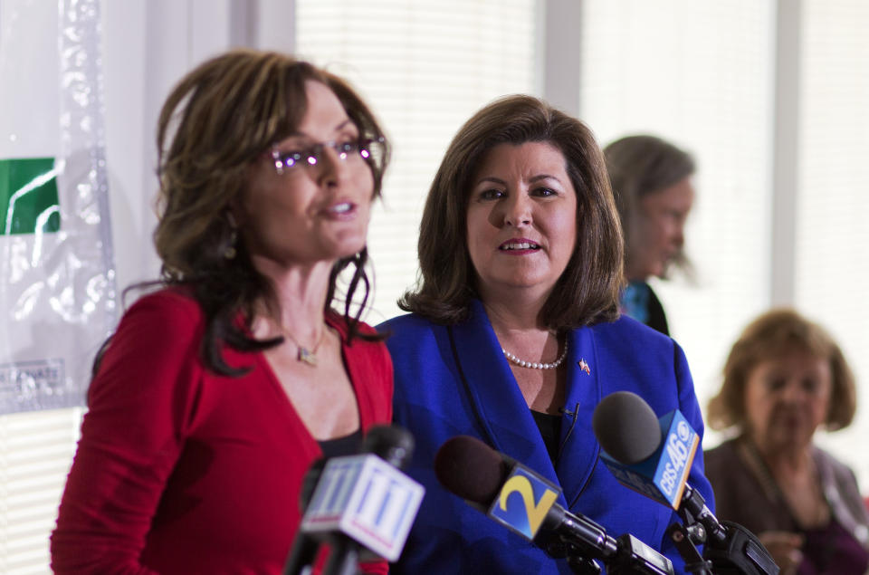 Republican candidate for U.S. Senate Karen Handel, right, looks on as former Alaska governor and 2008 Republican vice presidential nominee Sarah Palin, left, speaks at a county women's group meeting on her behalf, Thursday, April 3, 2014, in Union City, Ga. Palin is riding to the defense of the only Republican woman in the nomination fight for Georgia's open Senate seat, hitting back against GOP rival David Perdue's apparent dismissal of Karen Handel's high school education. (AP Photo/David Goldman)