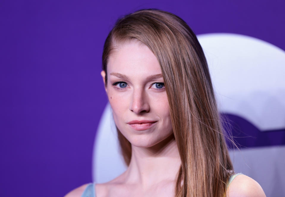 Woman with straight hair and strapless outfit posing at an event