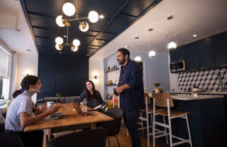 Gil Hirak (R), head of US operations and community of Quarters speaks with colleagues in the community living area of Quarters Co-Living in the Lower East Side on July 24, 2019 in New York City. Nandita Iyer landed in New York from Bombay without knowing anyone, but she didn't want to live alone in a 