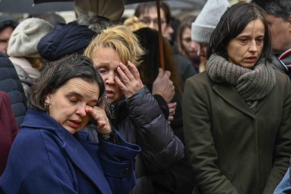 Mourners stand outside the headquarters of Charles University after a mass shooting in Prague, Czech Republic, Friday, Dec. 22, 2023. A lone gunman opened fire at a university on Thursday, killing more than a dozen people and injuring scores of people. (AP Photo/Denes Erdos)