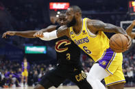 Los Angeles Lakers forward LeBron James (6) drives against Cleveland Cavaliers guard Caris LeVert (3) during the first half of an NBA basketball game Tuesday, Dec. 6, 2022, in Cleveland. (AP Photo/Ron Schwane)