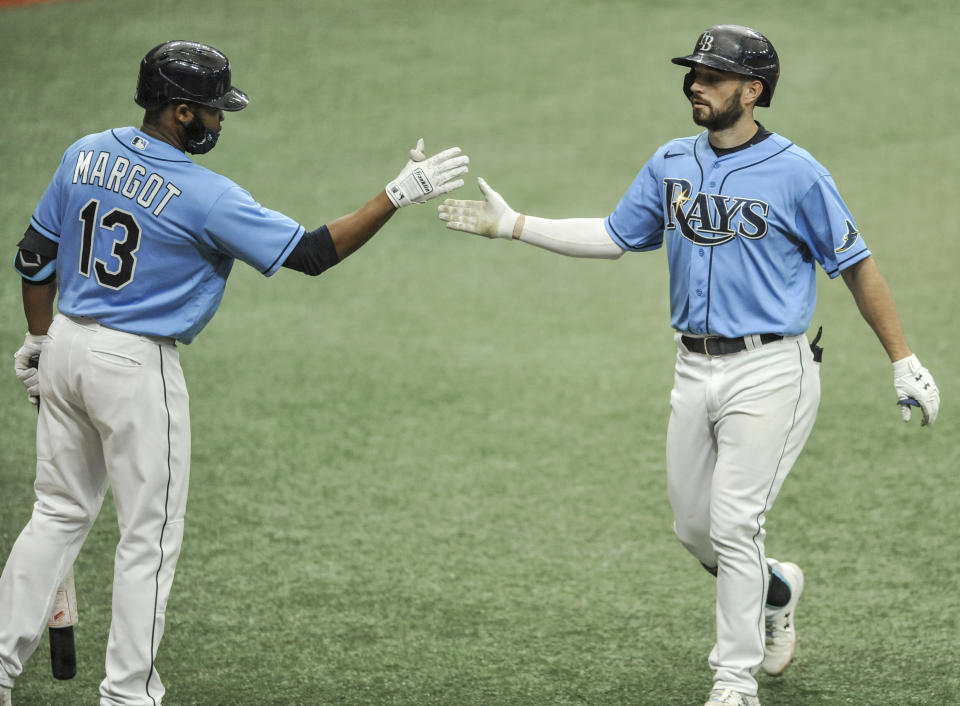 Tampa Bay Rays' Manuel Margot, left, congratulates Brandon Lowe, right, after Lowe's solo home run off New York Yankees starter James Paxton during the seventh inning of a baseball game Sunday, Aug. 9, 2020, in St. Petersburg, Fla. (AP Photo/Steve Nesius)