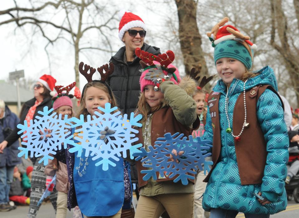 Girl Scouts walk down Main Street as part of a past Falmouth Christmas parade.