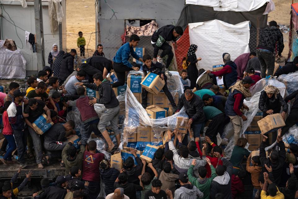 Palestinians loot a humanitarian aid truck as it crossed into the Gaza Strip in Rafah, Sunday, Dec. 17, 2023.