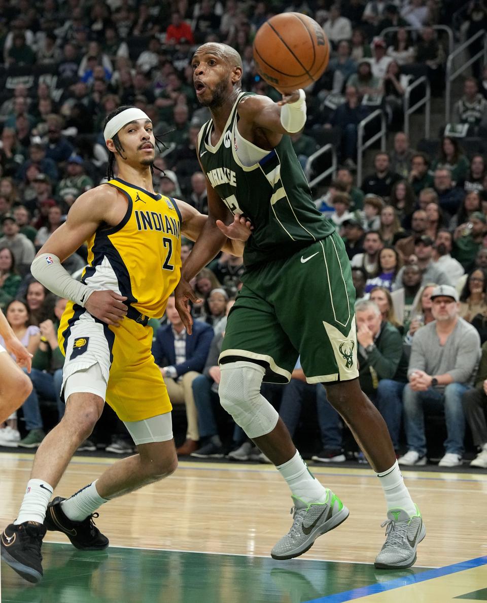 Milwaukee Bucks forward Khris Middleton (22) is guarded by Indiana Pacers guard Andrew Nembhard (2) while making a pass during the first half of their playoff game on Tuesday at Fiserv Forum in Milwaukee.