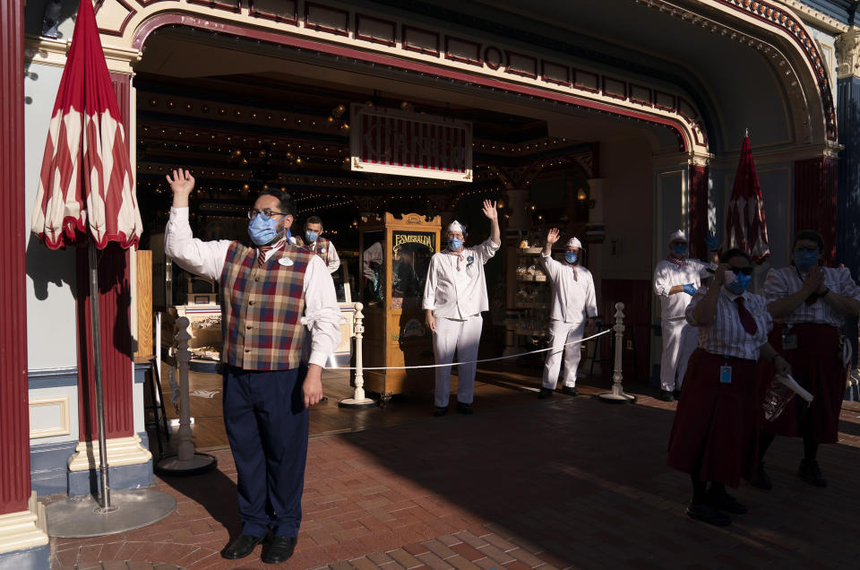 Image: Employees wave as guests walk along Main Street USA at Disneyland in Anaheim, Calif., on April 30, 2021. (Jae C. Hong / AP)