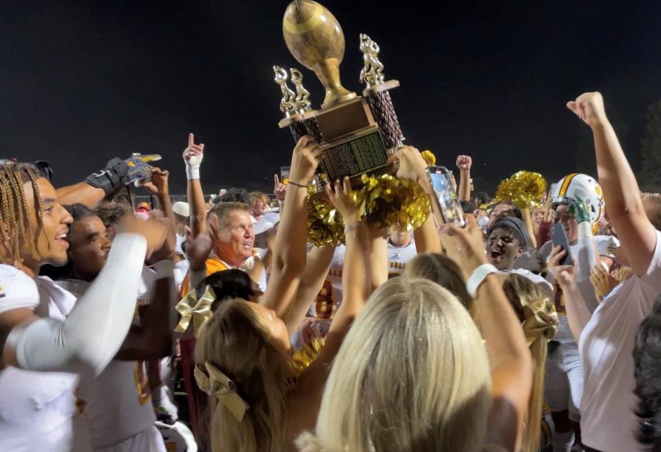 The Simi Valley High football team celebrates with the James Tutino Memorial Trophy after beating rival Royal 49-12 on Friday night at Royal High.
